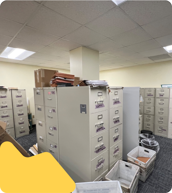 Office filled with vertical file cabinets and post office boxes on the floor