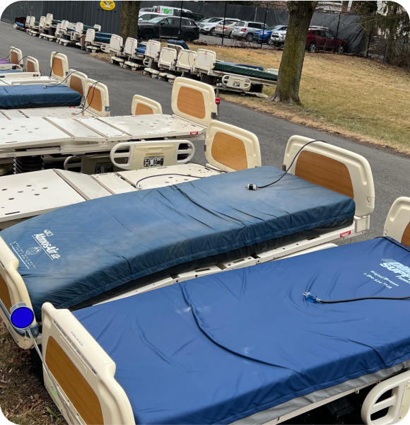 Old hospital beds with mattresses outside hospital for recycling