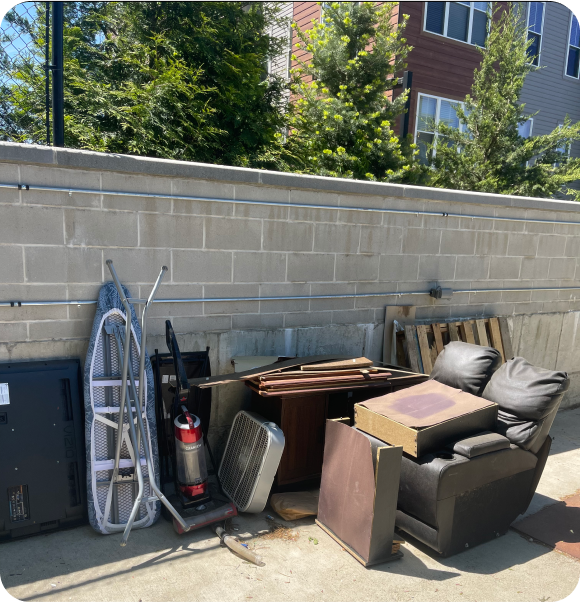 Various bulk items including TV, couch, and wood in a residential condominium
